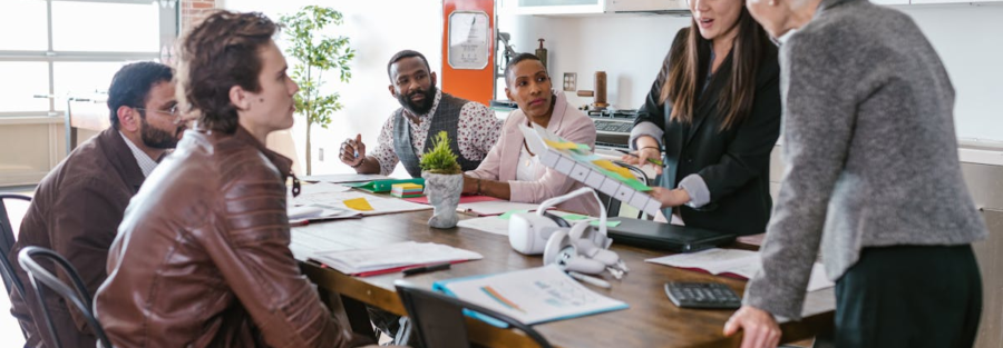 Colleagues engaged in a collaborative business meeting around a table in a modern office setting.